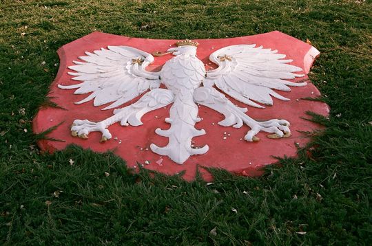 OSTRÓWEK_Orzeł na gazonie przed bramą kościelną w Ostrówku